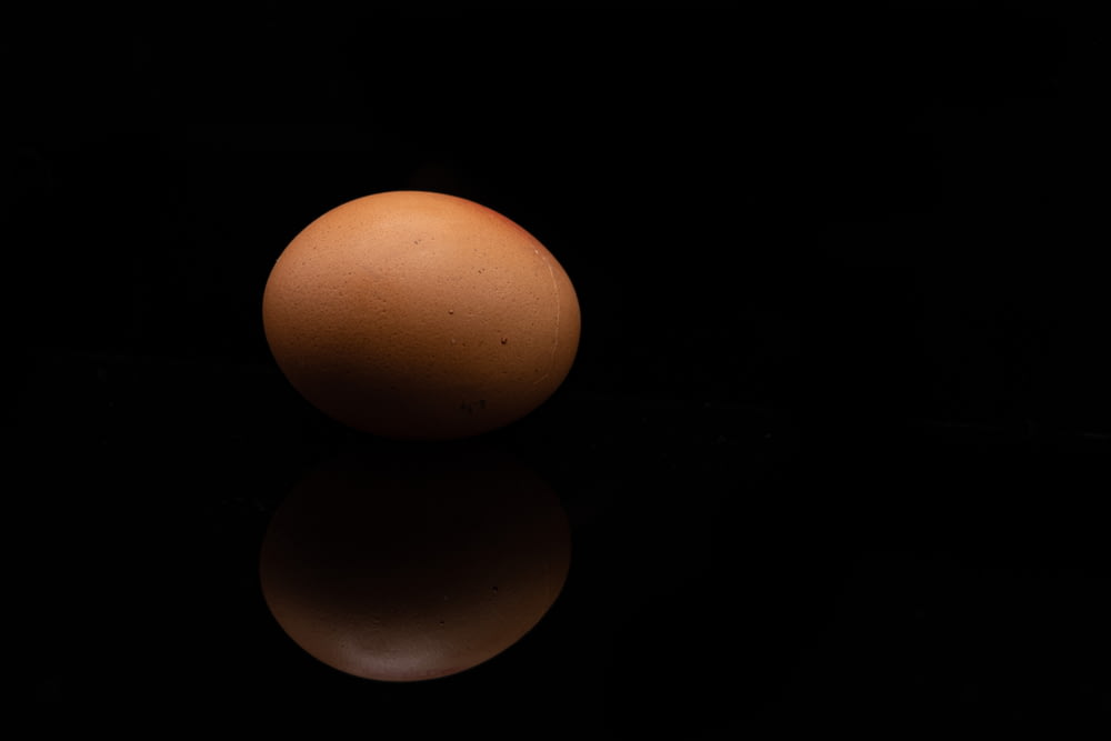 a brown egg sitting on top of a black table
