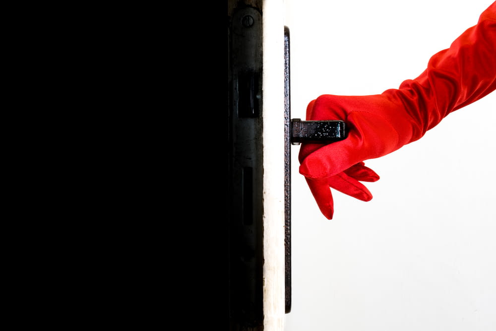 a person in red gloves is opening a door
