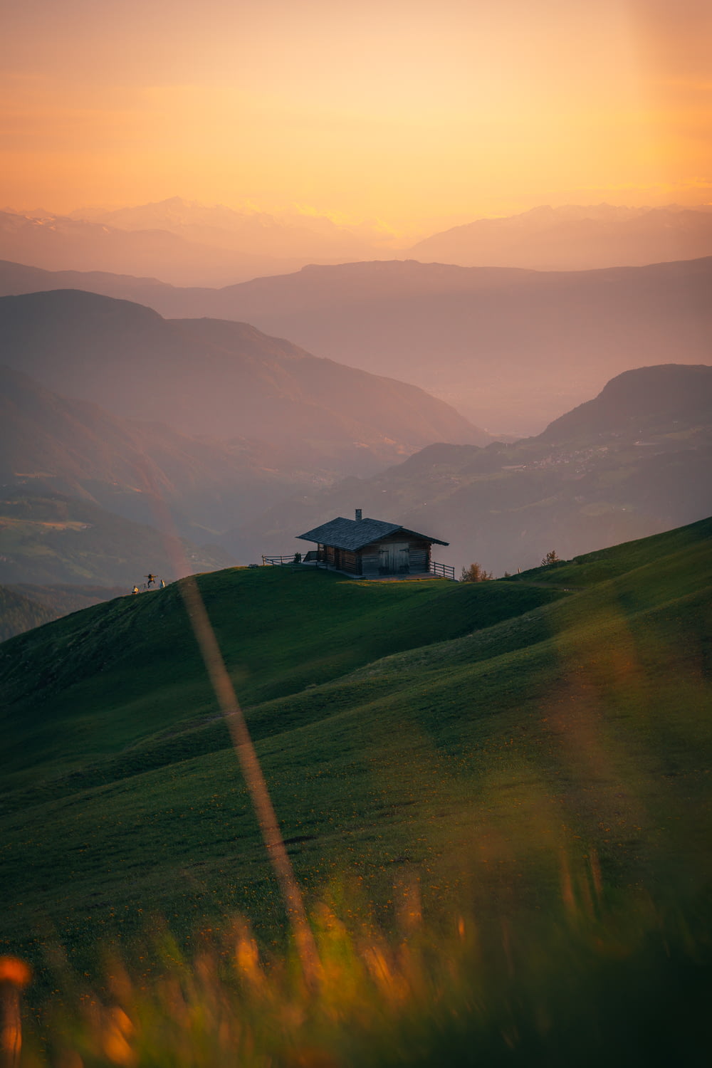 a house on top of a hill with mountains in the background