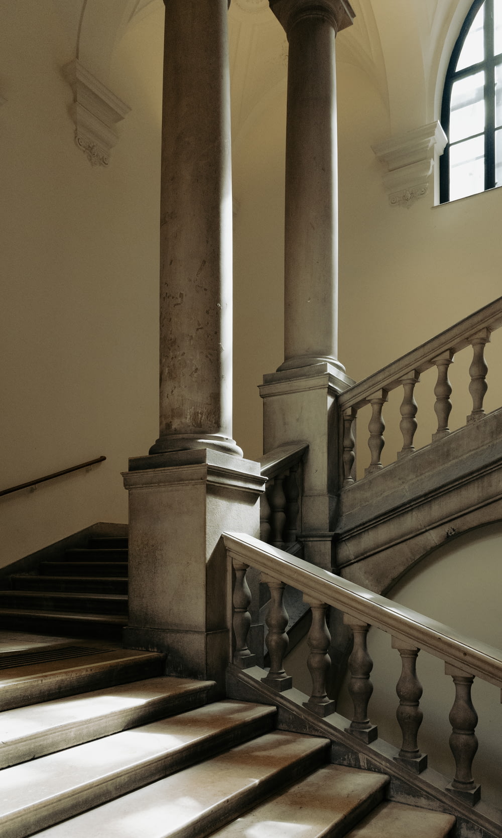 a staircase in a building with columns and a window