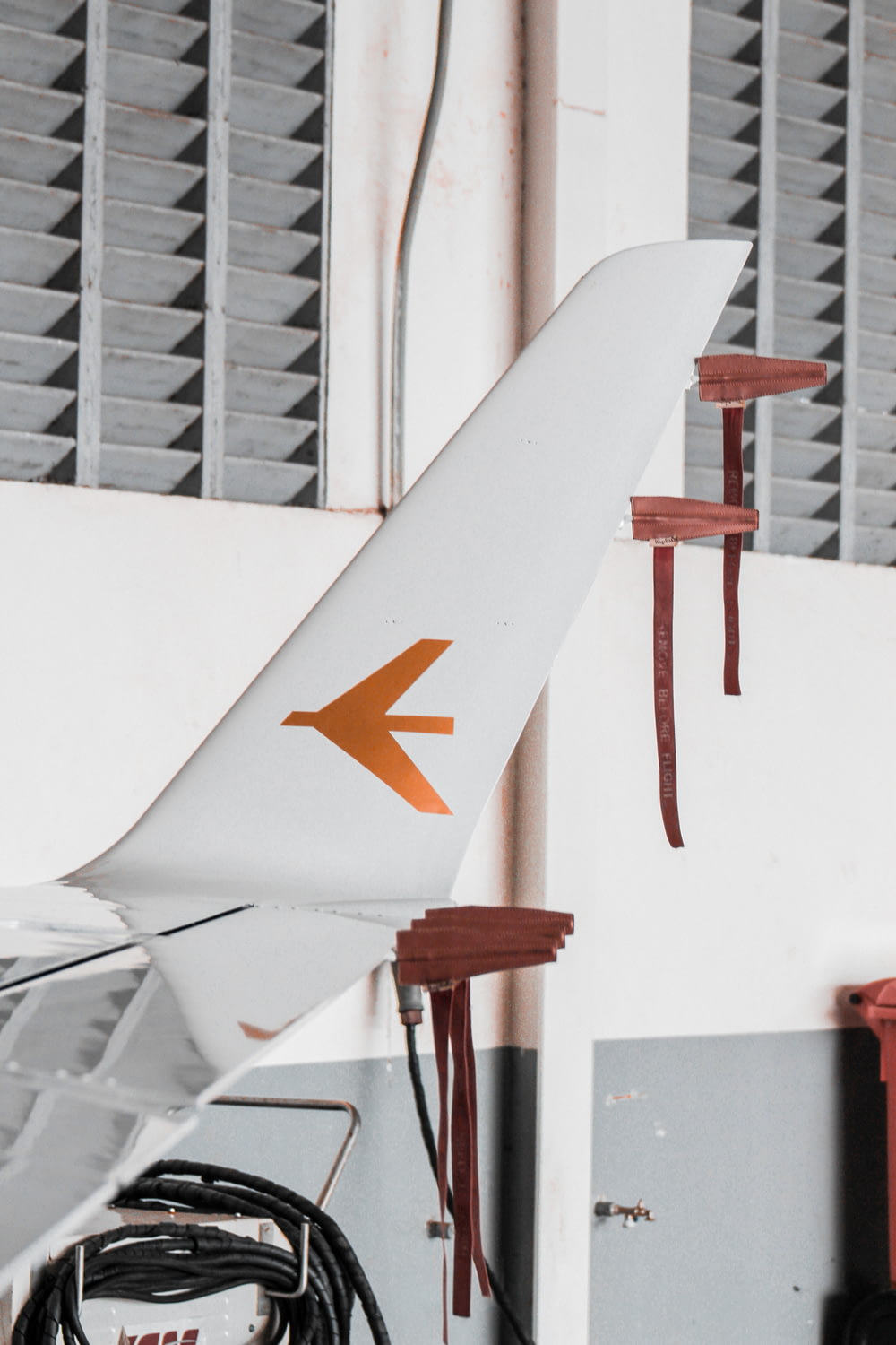 a white airplane with an orange arrow painted on it