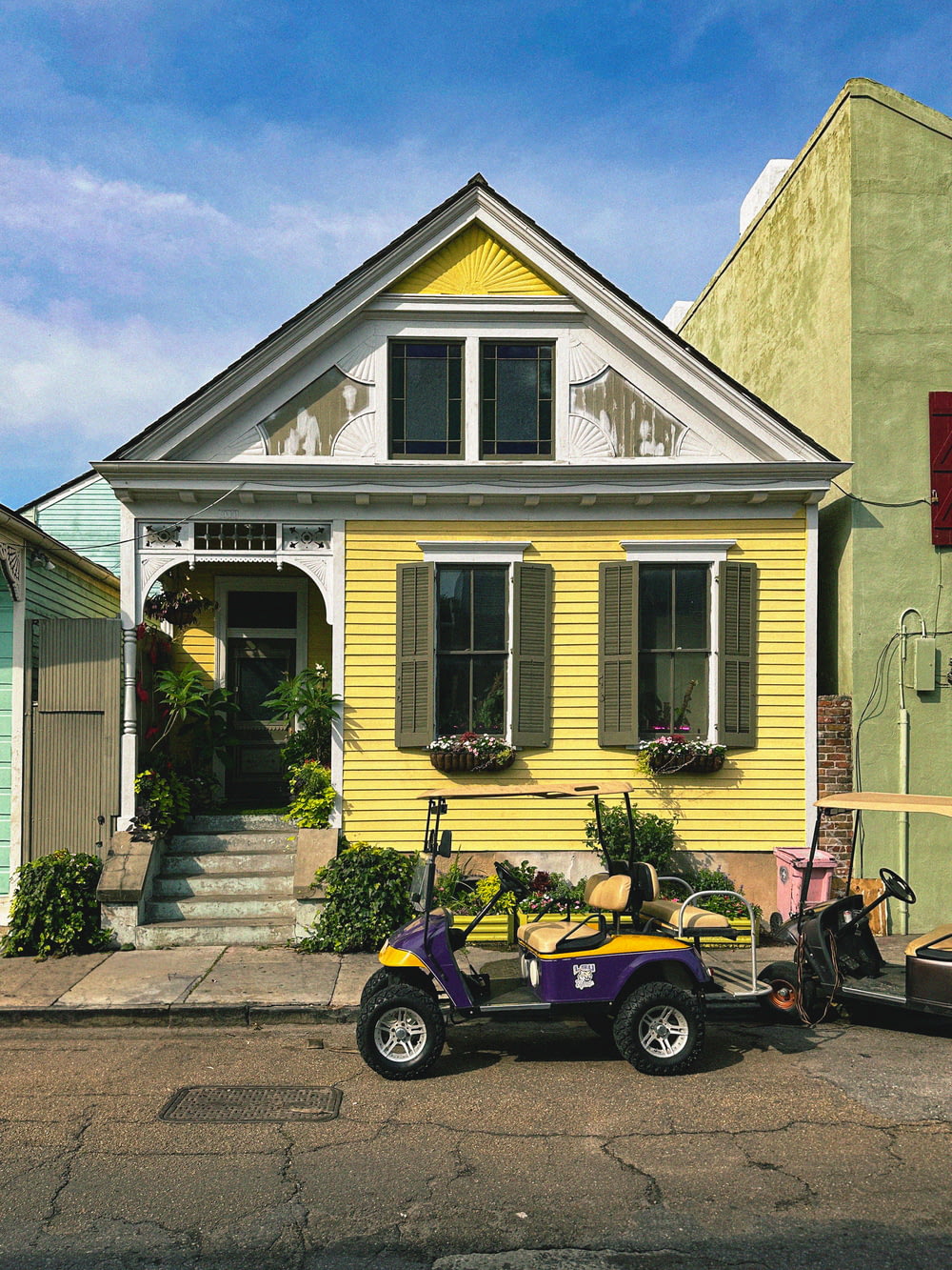 Un carrito de golf estacionado frente a una casa amarilla