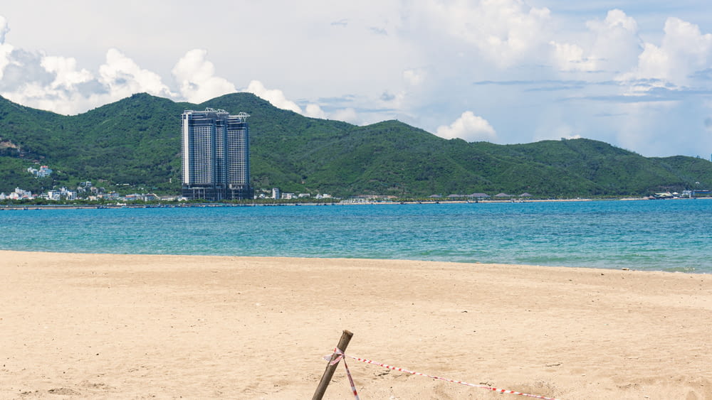 a beach with a tall building in the background