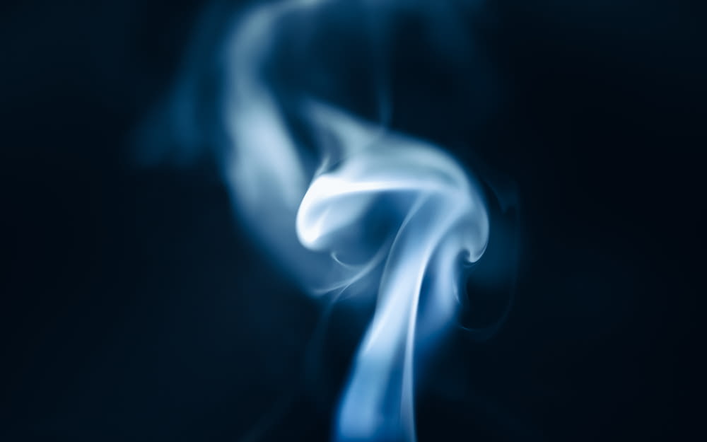 a blurry photo of blue smoke on a black background