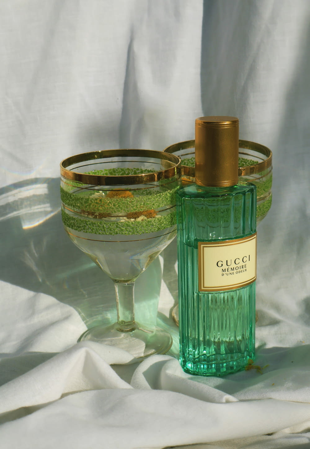 a bottle of perfume sitting next to a glass bowl