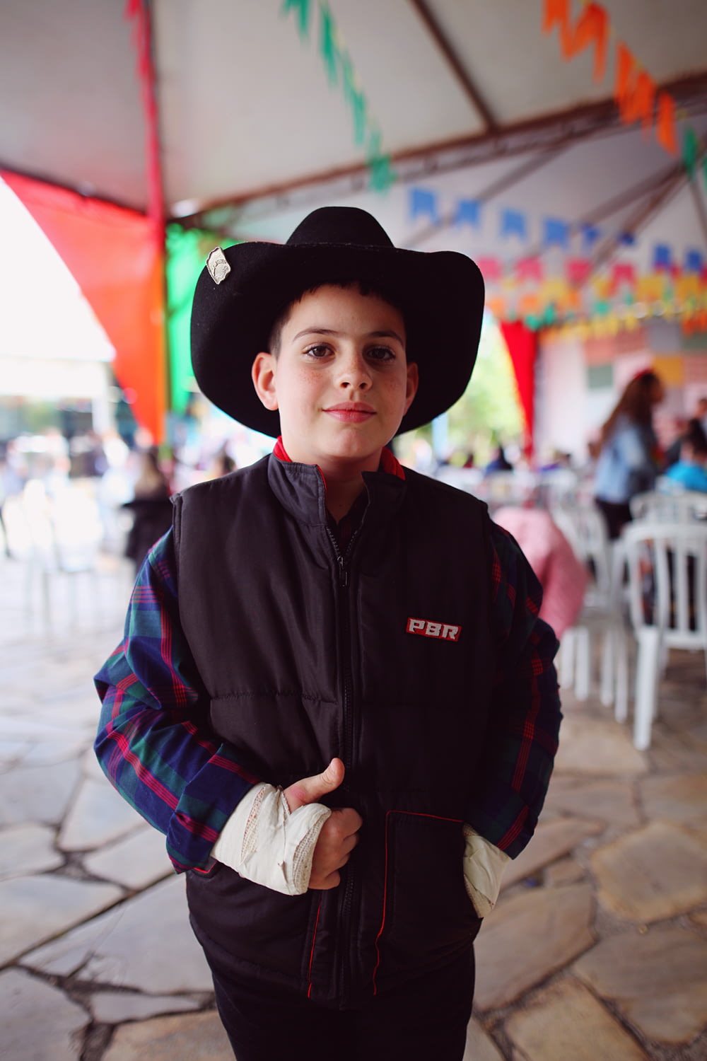 a young boy wearing a cowboy hat and jacket