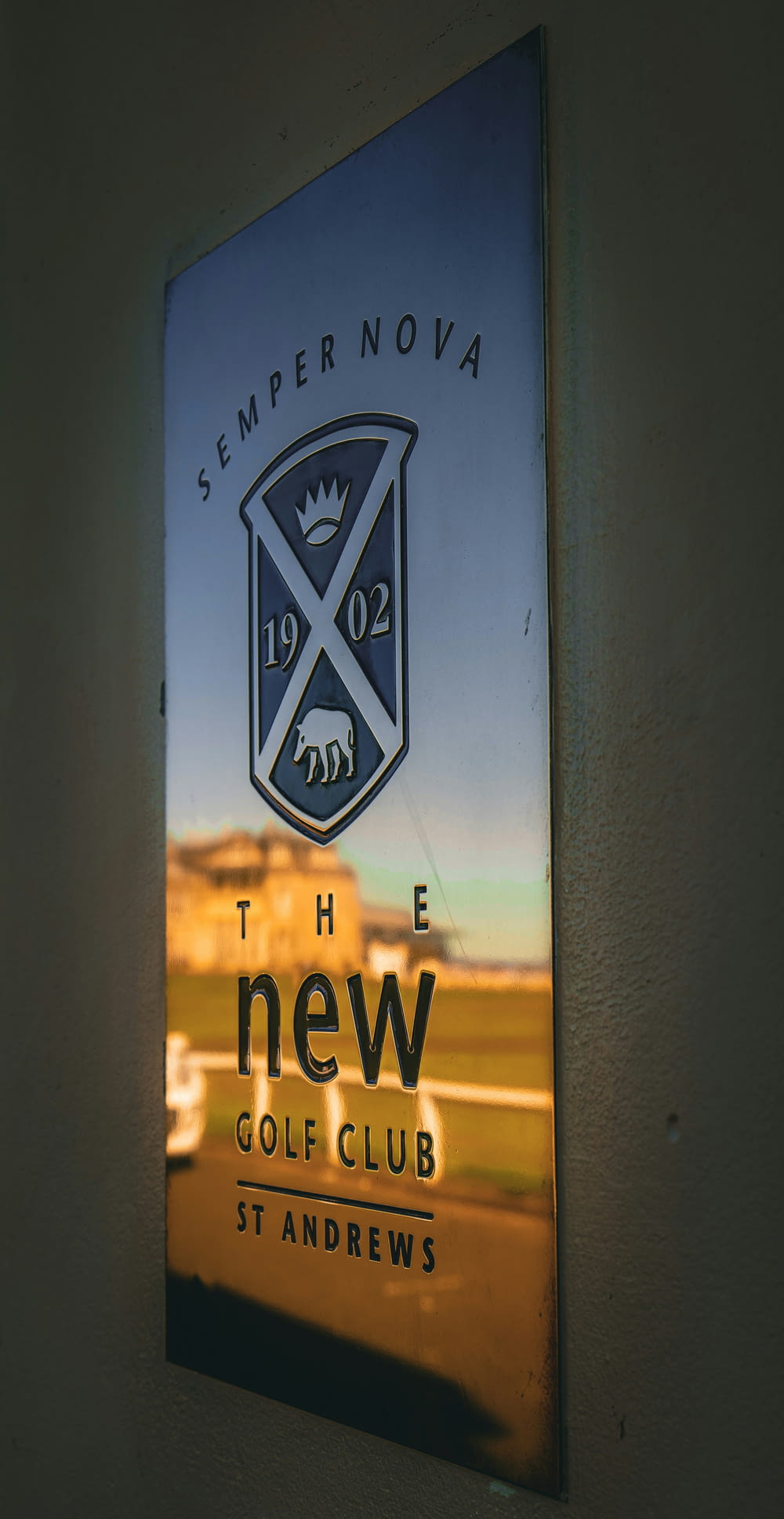 a sign on the side of a building that says the new golf club st andrews