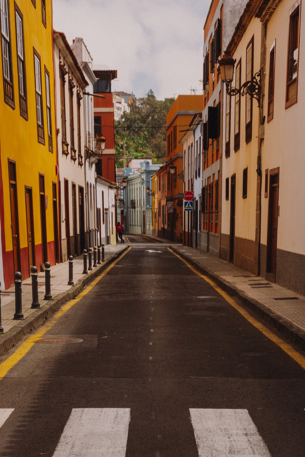 an empty street with a yellow building on the side