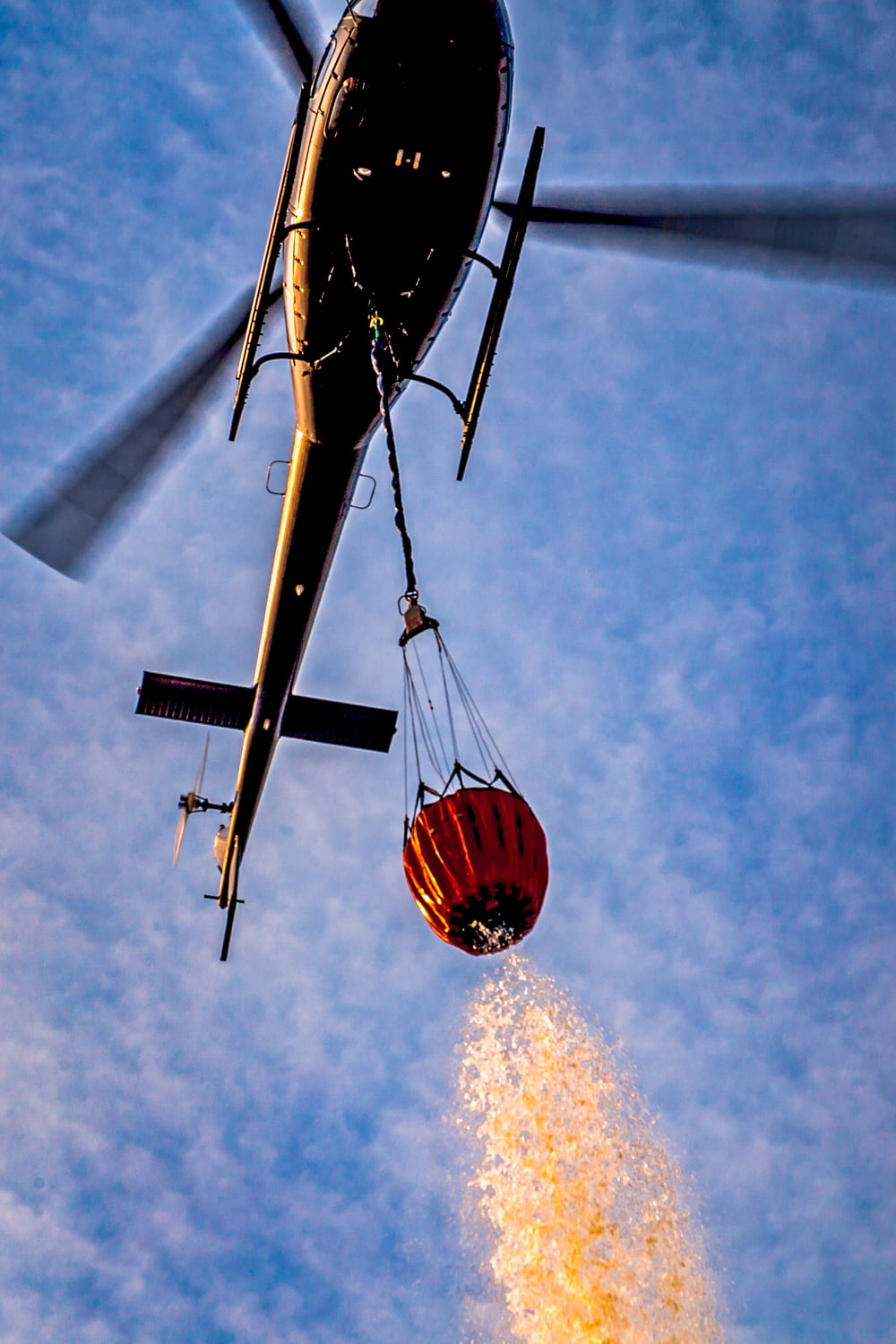 a helicopter dropping a red balloon into the air