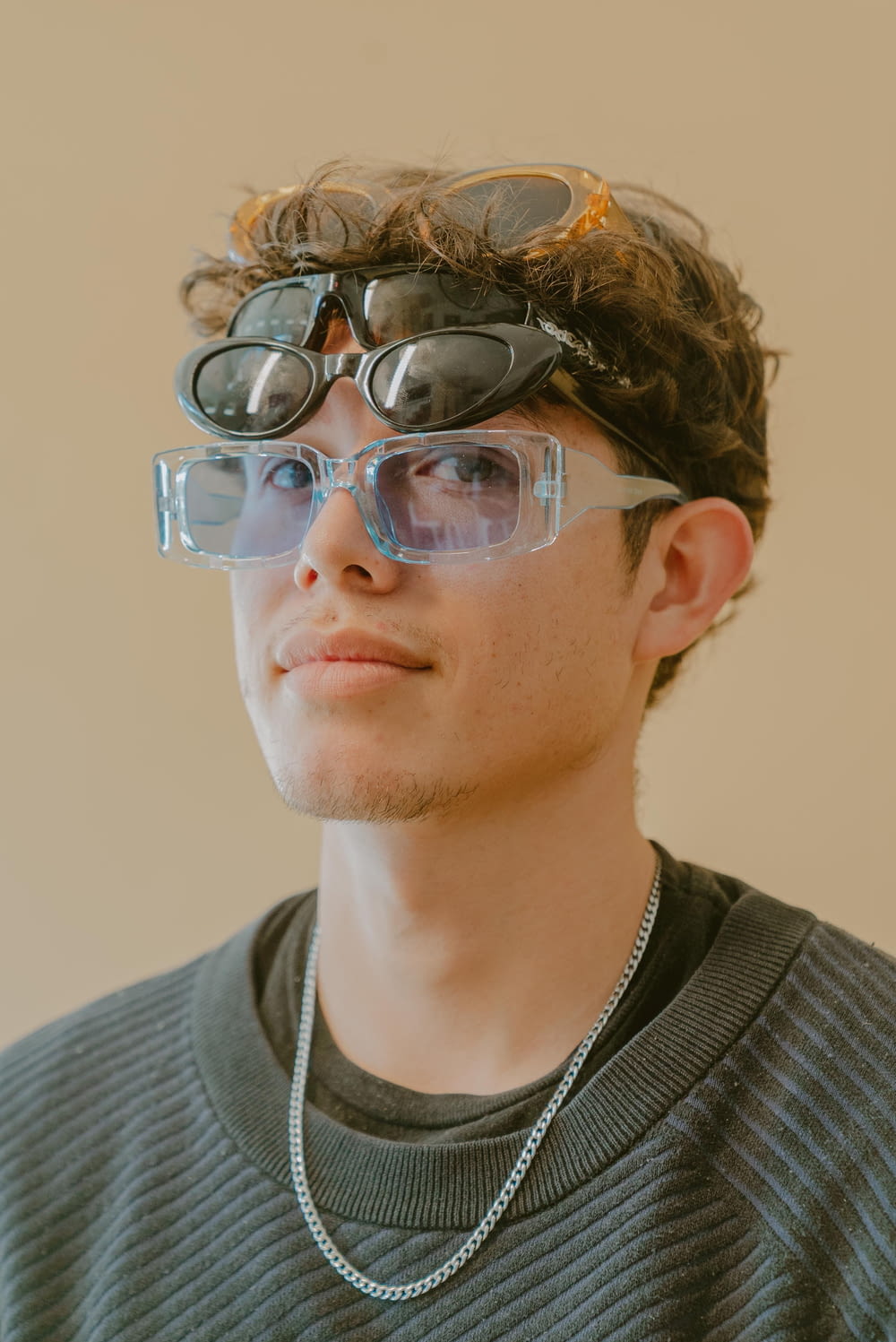 a young man wearing goggles and a necklace