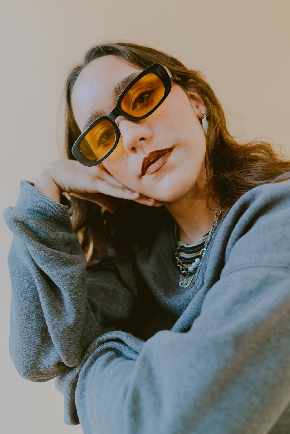 a woman in a gray sweater and yellow sunglasses