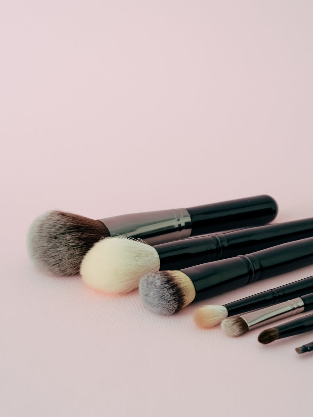 a group of makeup brushes laying on top of each other