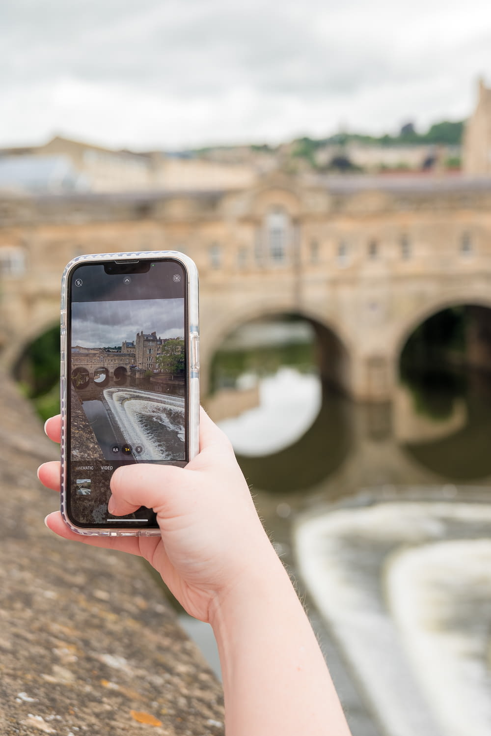 a person taking a picture of a bridge with a cell phone