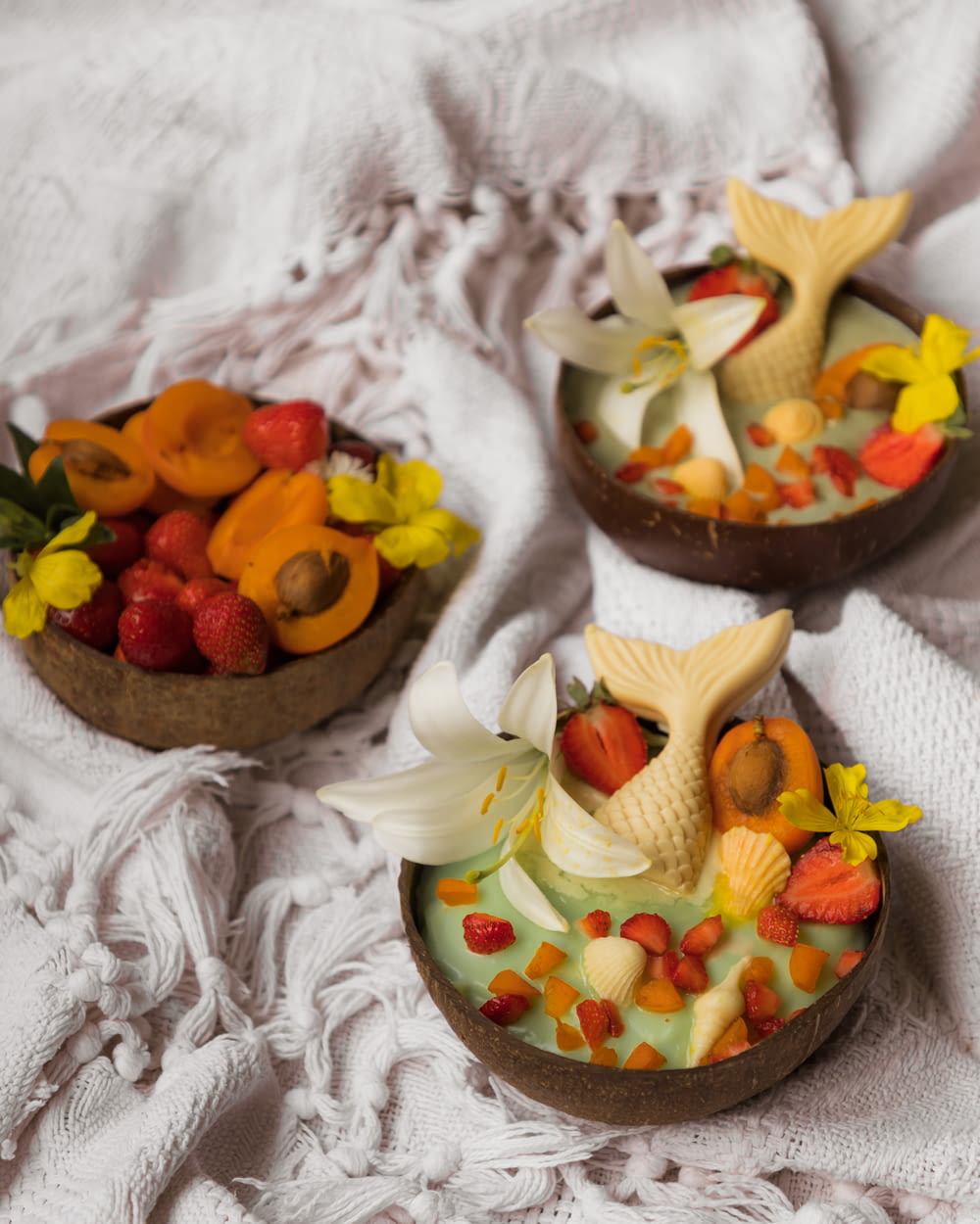 three small bowls filled with fruit and flowers