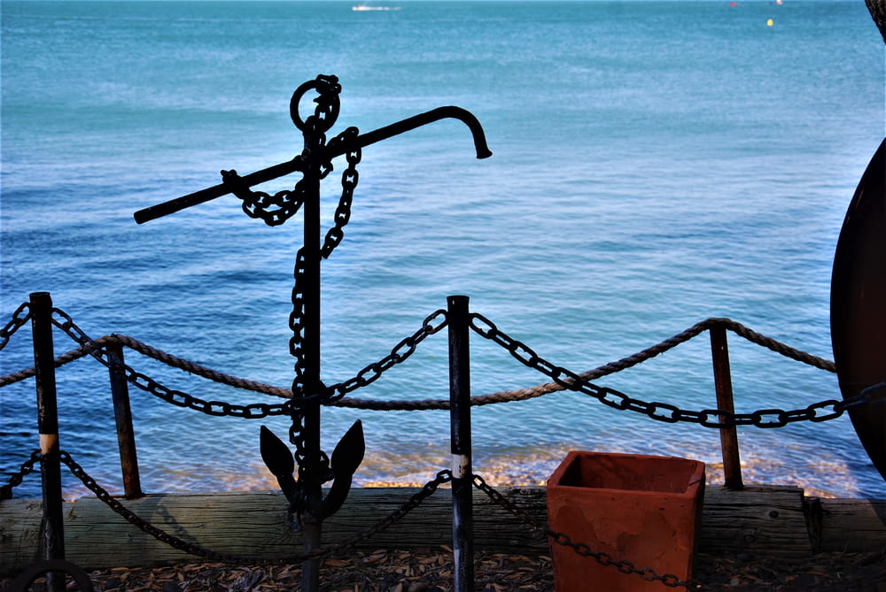 an anchor on a chain next to a body of water