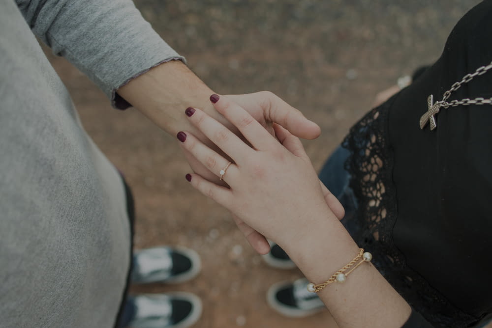 a close up of two people holding hands