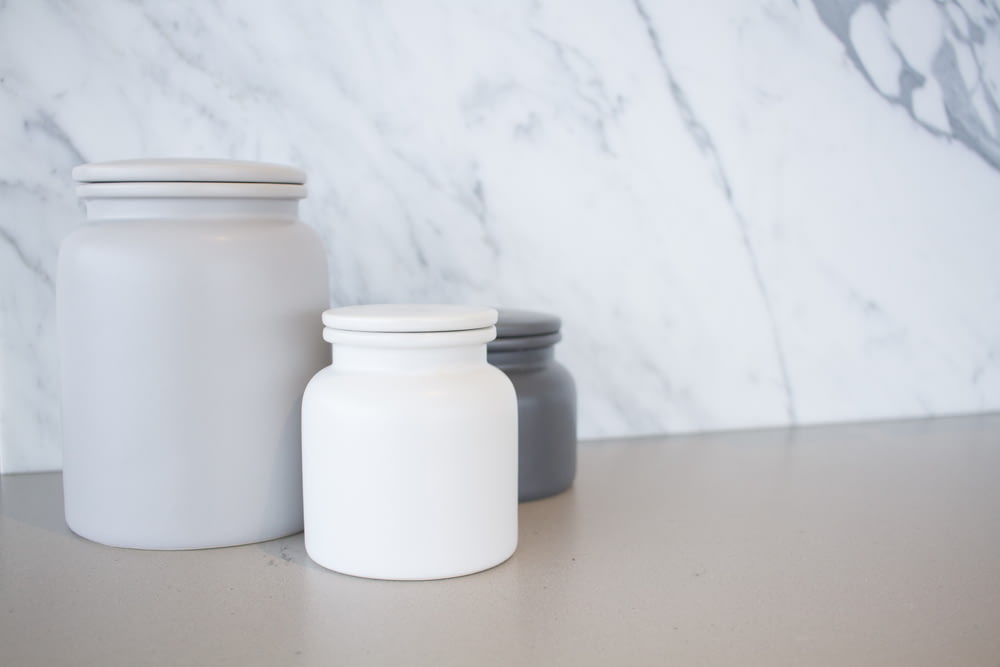 three jars sitting on a counter top next to each other