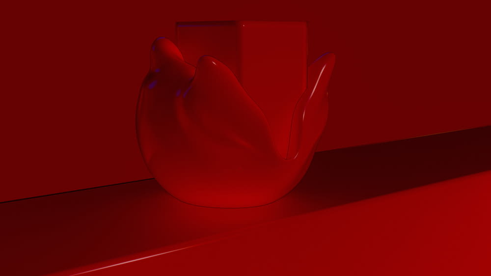 a red vase sitting on top of a counter