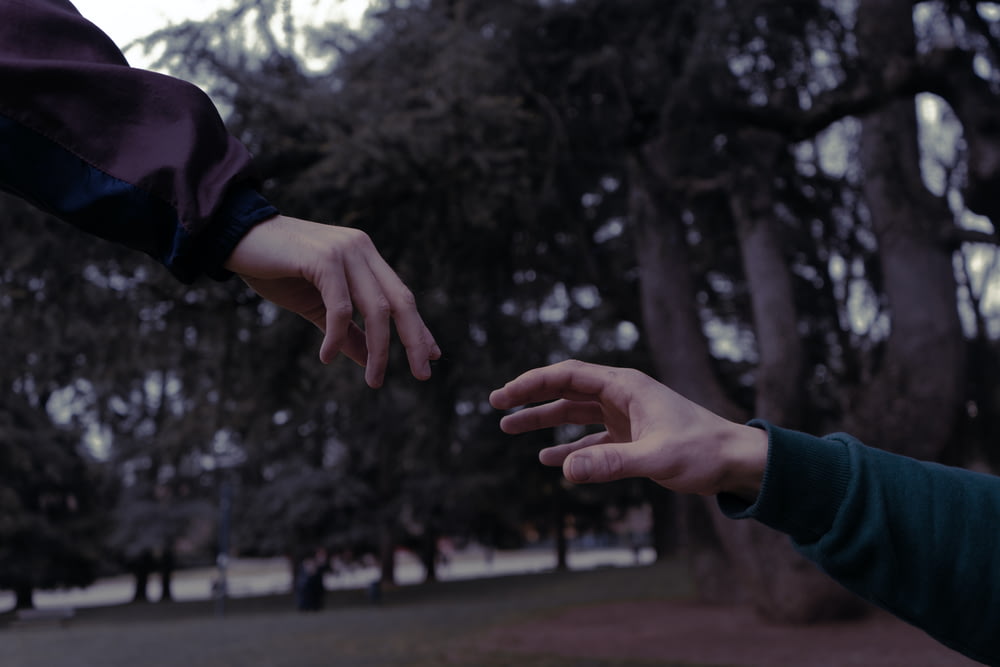 two people reaching out their hands to touch each other