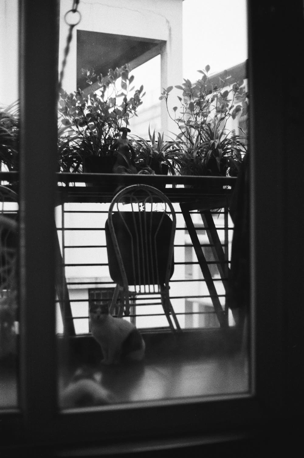 a black and white photo of a chair on a balcony