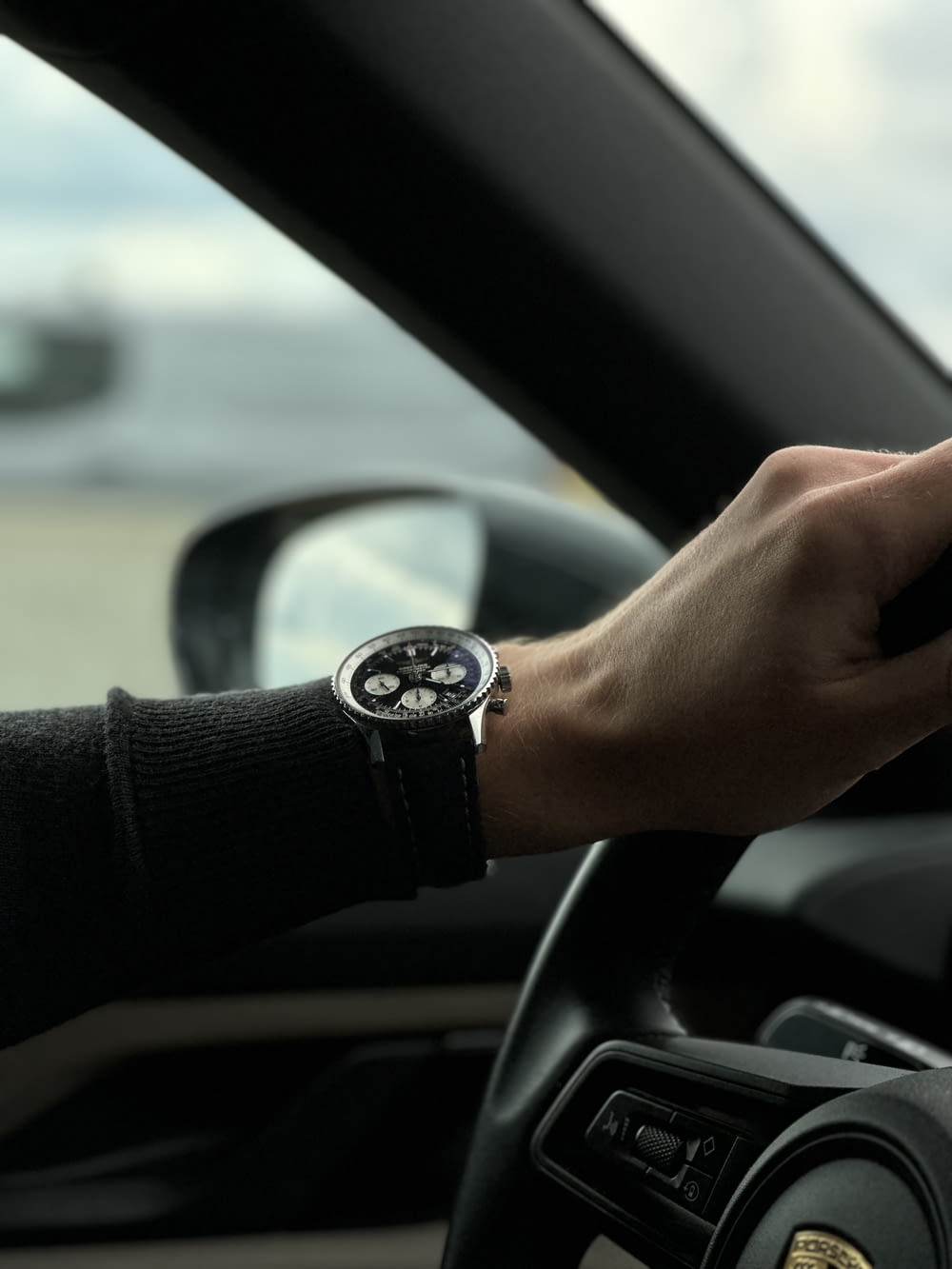 a person driving a car with a watch on their wrist
