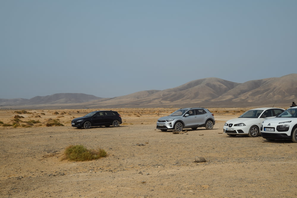 a couple of cars parked in the middle of a desert