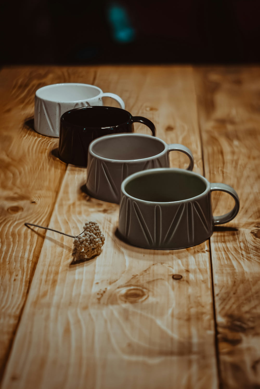 drei Kaffeetassen, die auf einem Holztisch sitzen