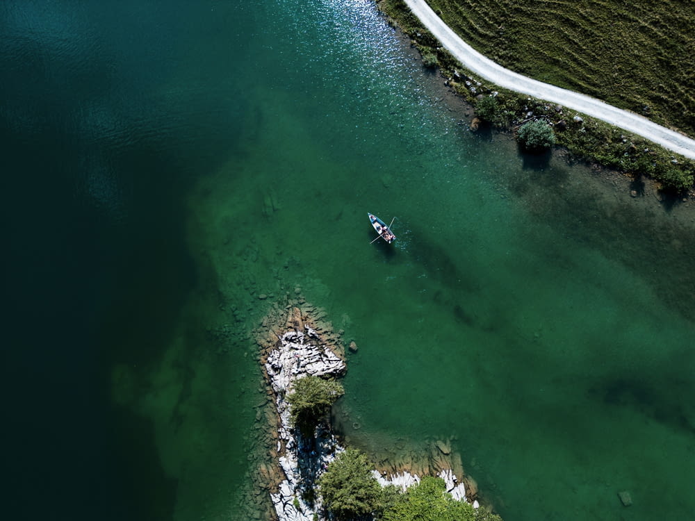 an aerial view of a lake with a boat in it