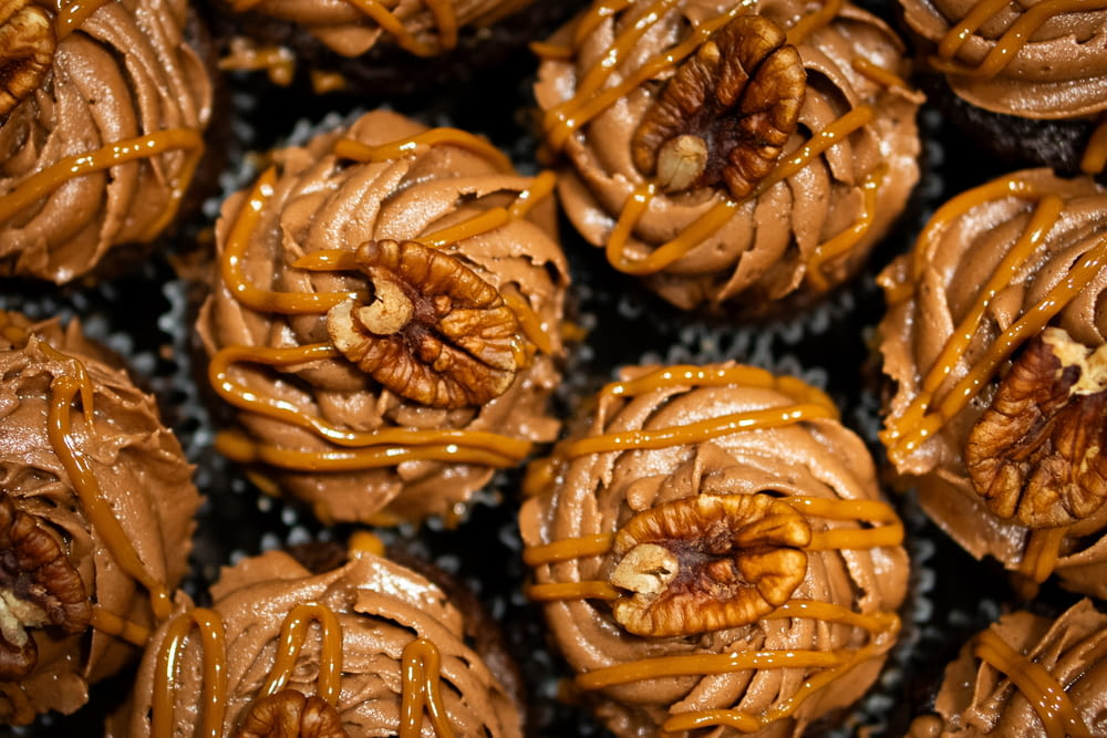 a close up of a bunch of cupcakes covered in caramel icing