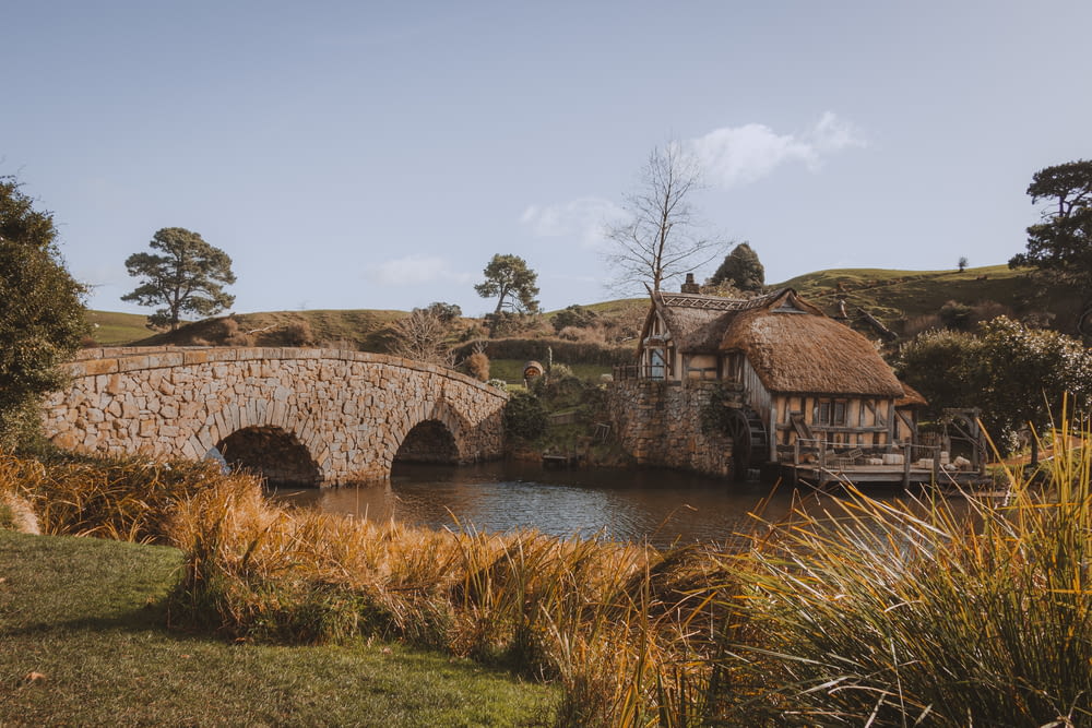 a stone bridge over a river with a house on top of it