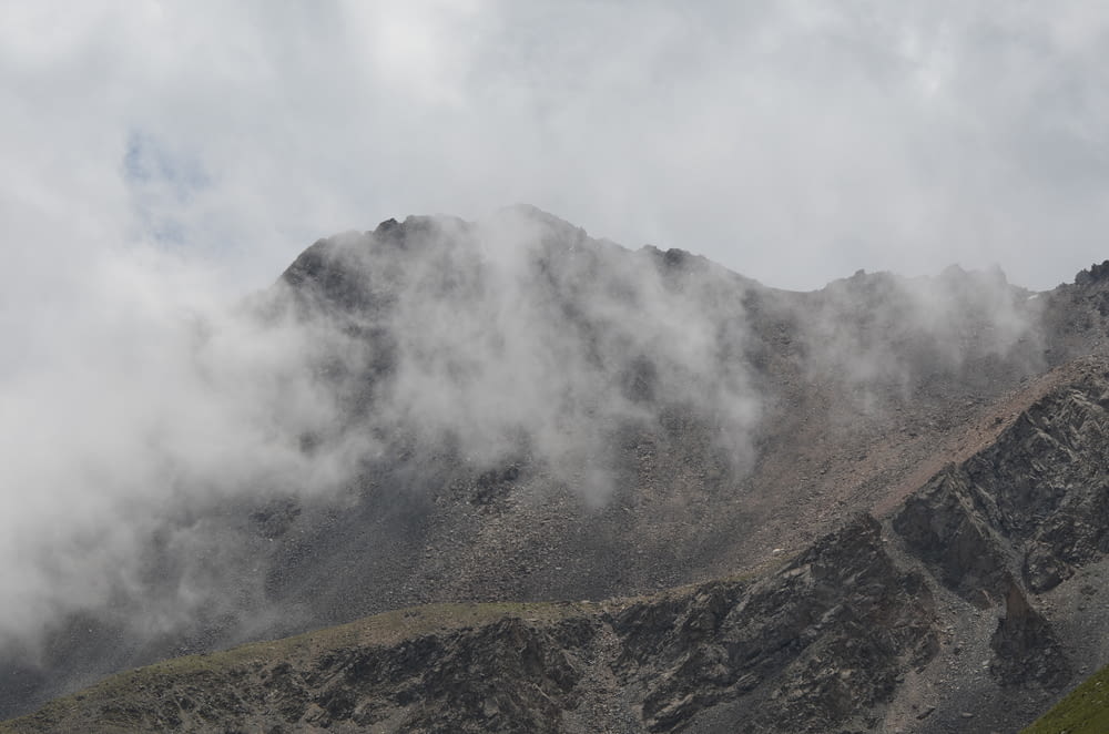 a mountain covered in clouds on a cloudy day