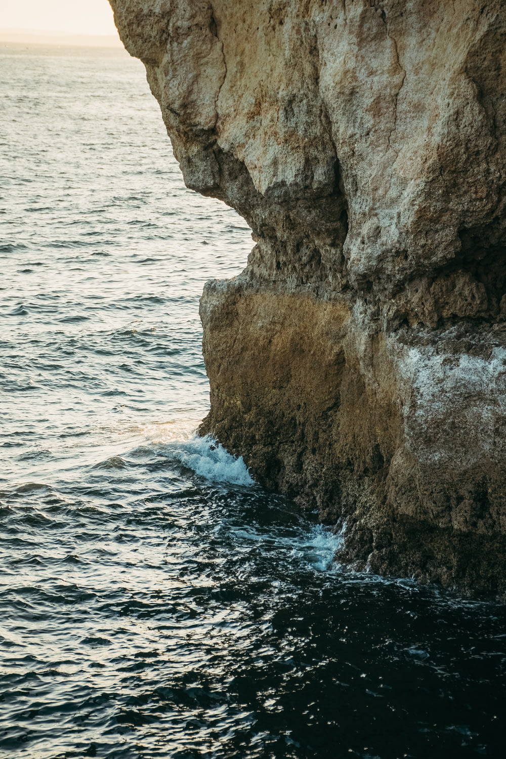 a person standing on the edge of a cliff next to the ocean