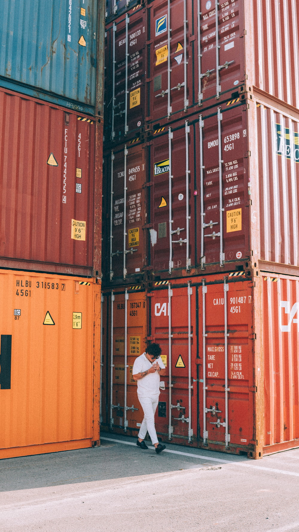 a person standing in front of a stack of shipping containers