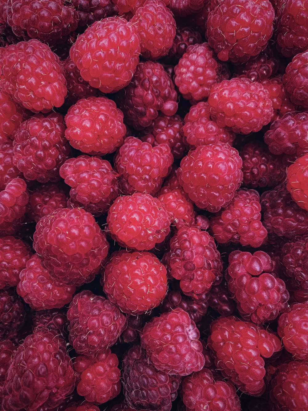a bunch of raspberries are piled together