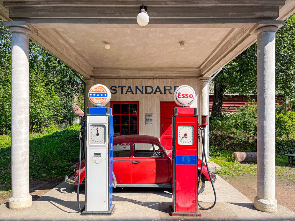 a red car is parked at a gas station