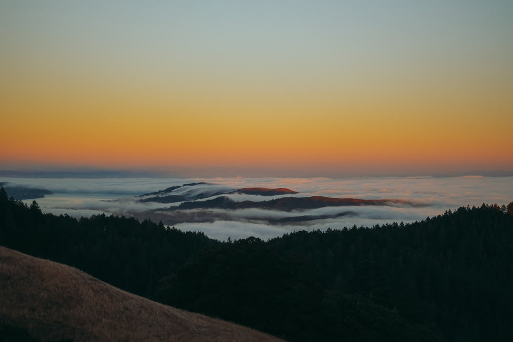 a sunset view of a foggy mountain range