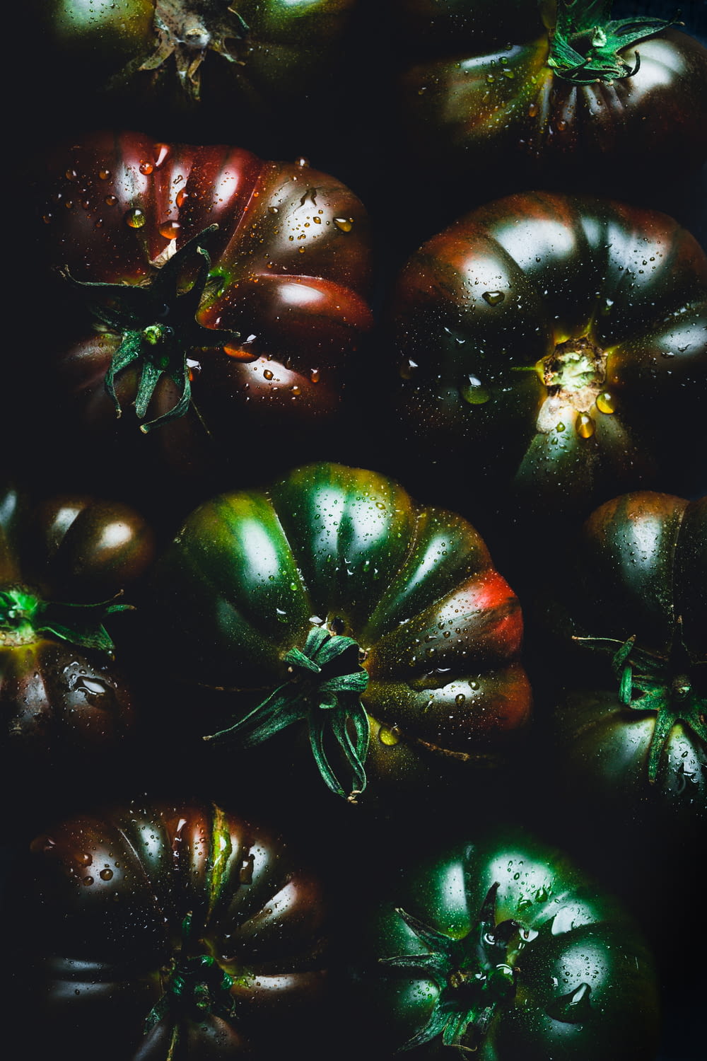 a bunch of green and red tomatoes on a table