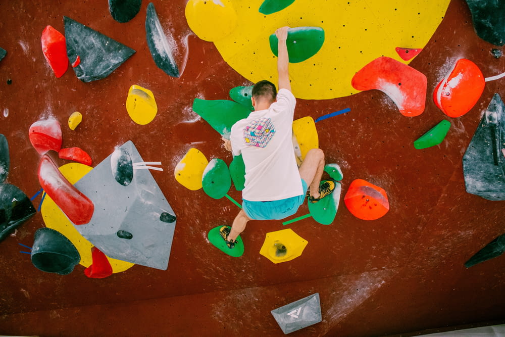 a young boy is climbing on a climbing wall