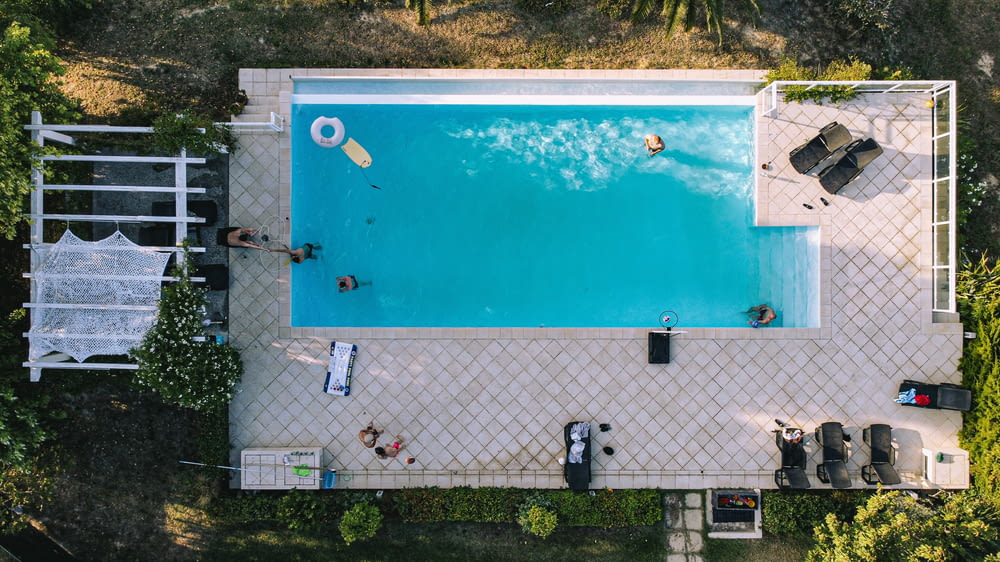 an aerial view of a swimming pool with people in it