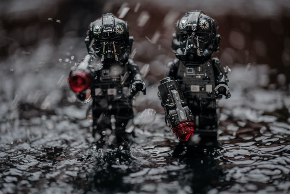 a couple of toy soldiers standing in a puddle of water