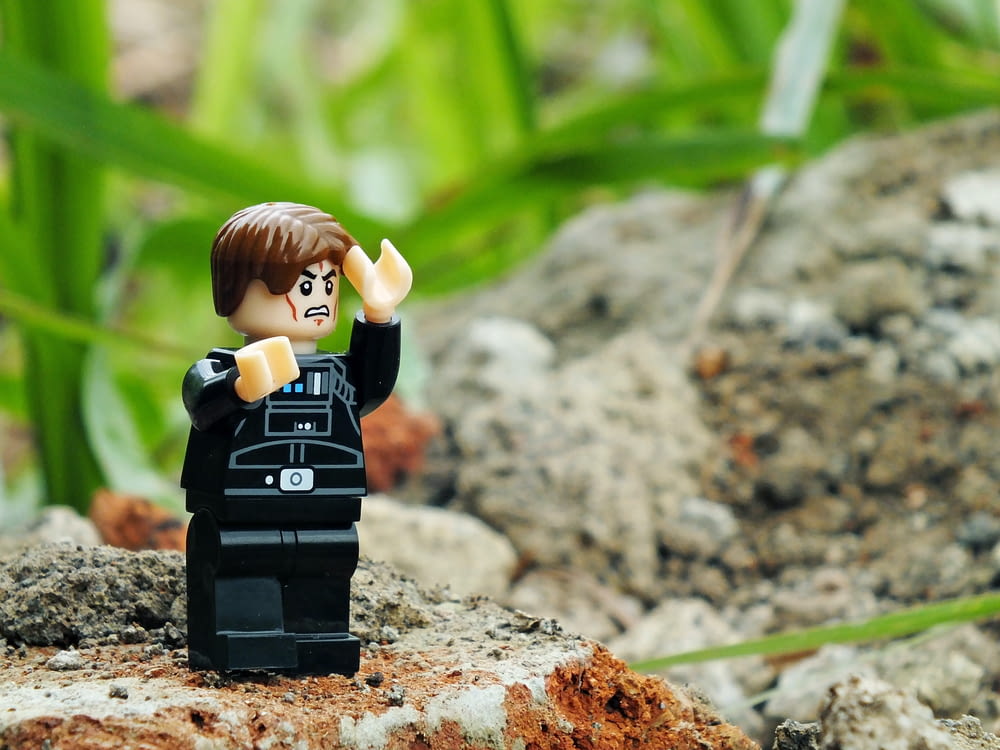 a lego star wars character is standing on a rock