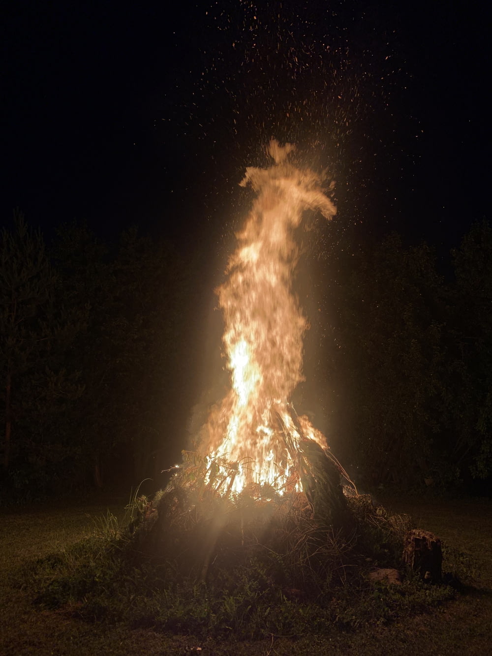 a bonfire is lit in a field at night