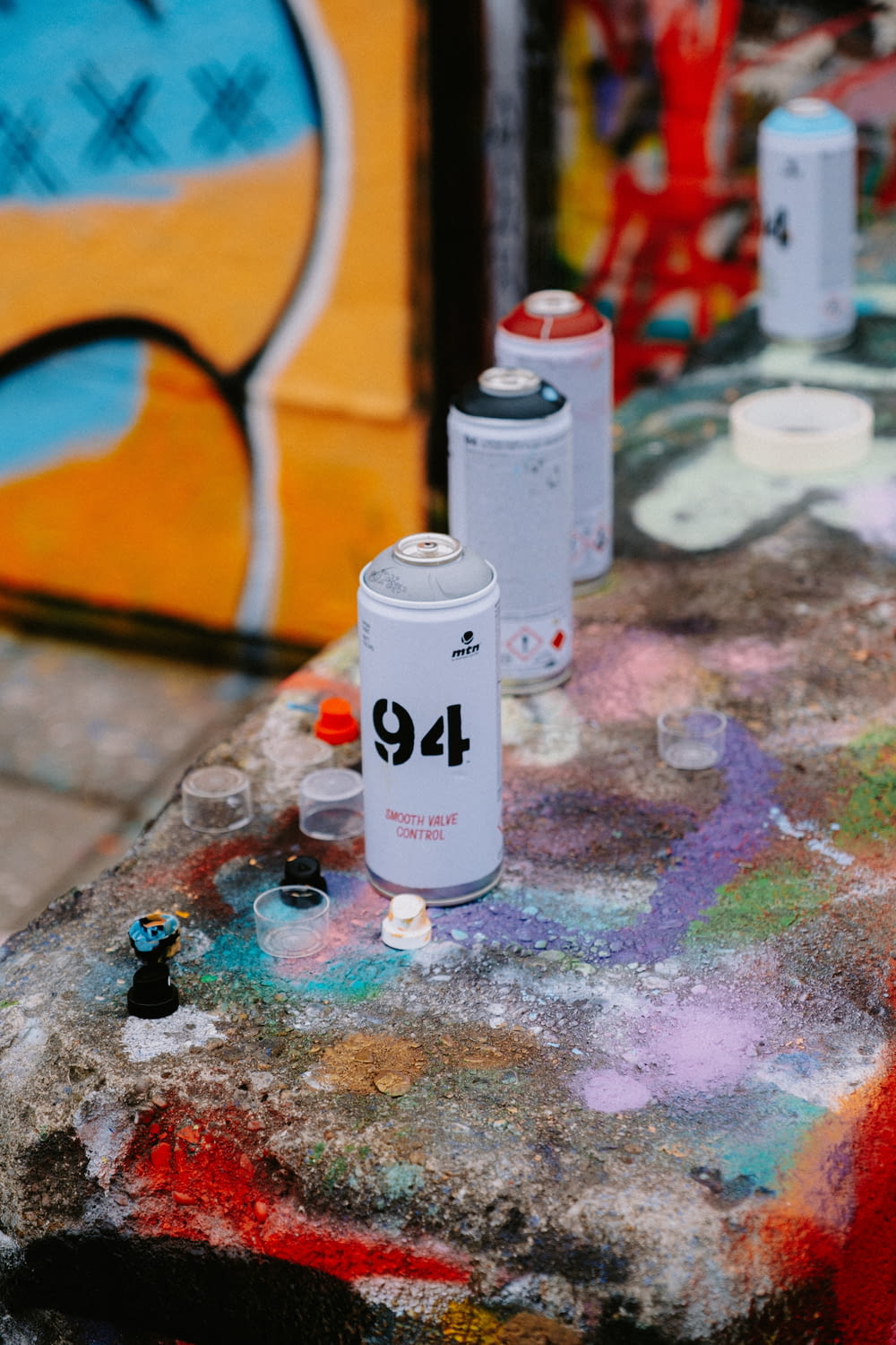 a group of cans sitting on top of a table covered in graffiti