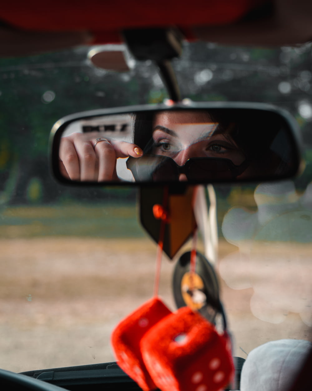 a woman's reflection in the side view mirror of a car