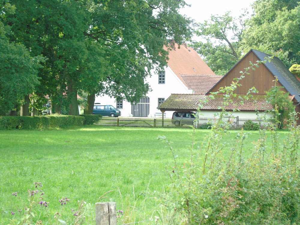 a house in the distance with a car parked in front of it