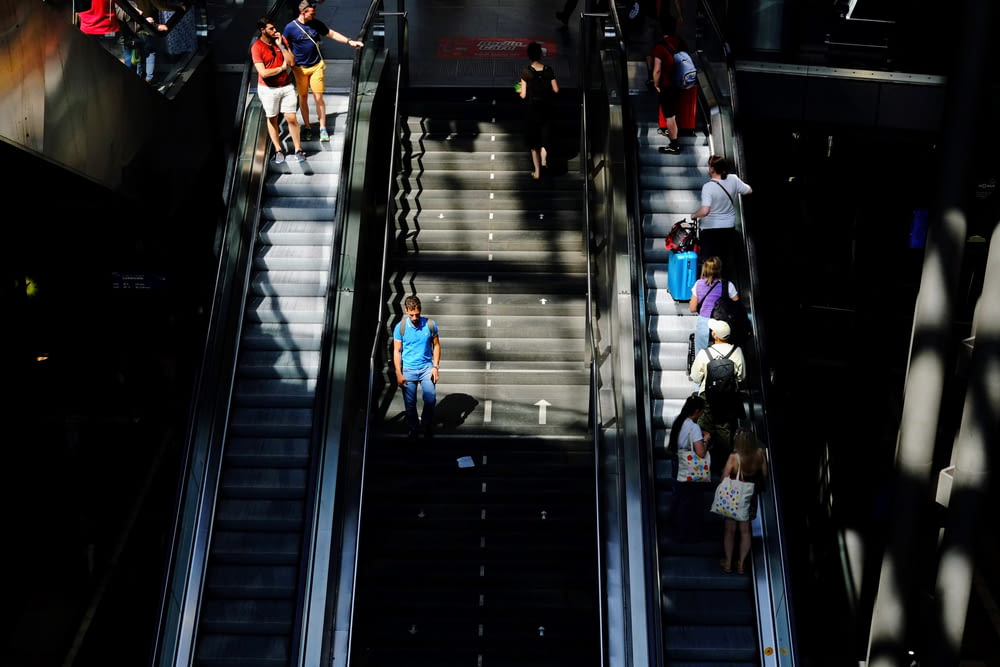 a group of people walking up and down an escalator