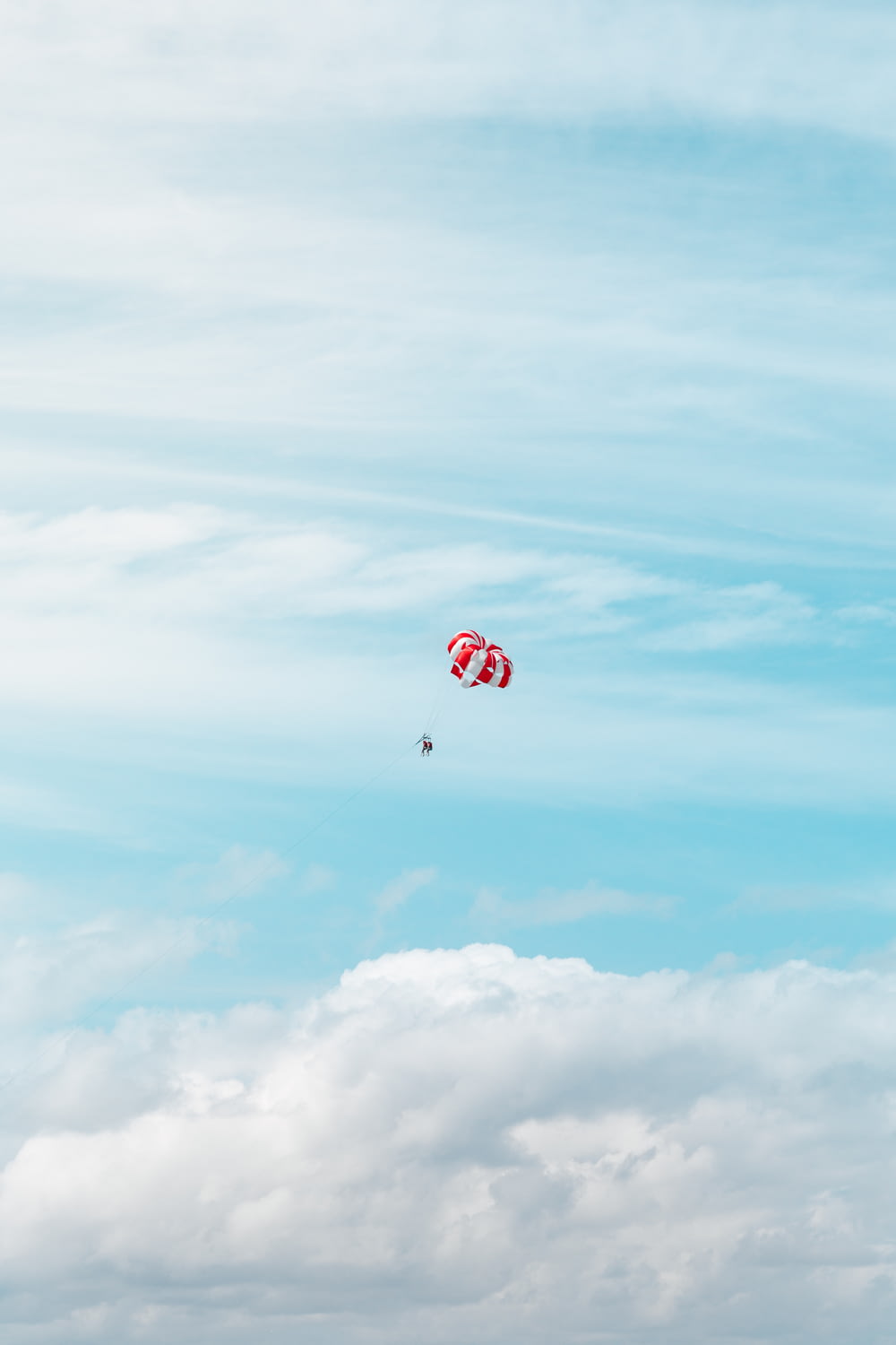 a couple of kites flying through a cloudy blue sky