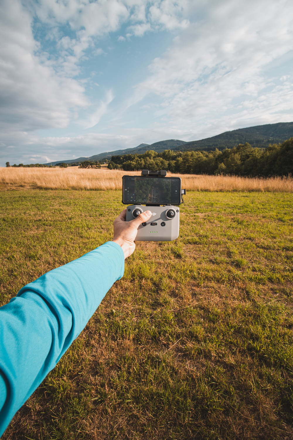 a person holding a remote control in a field