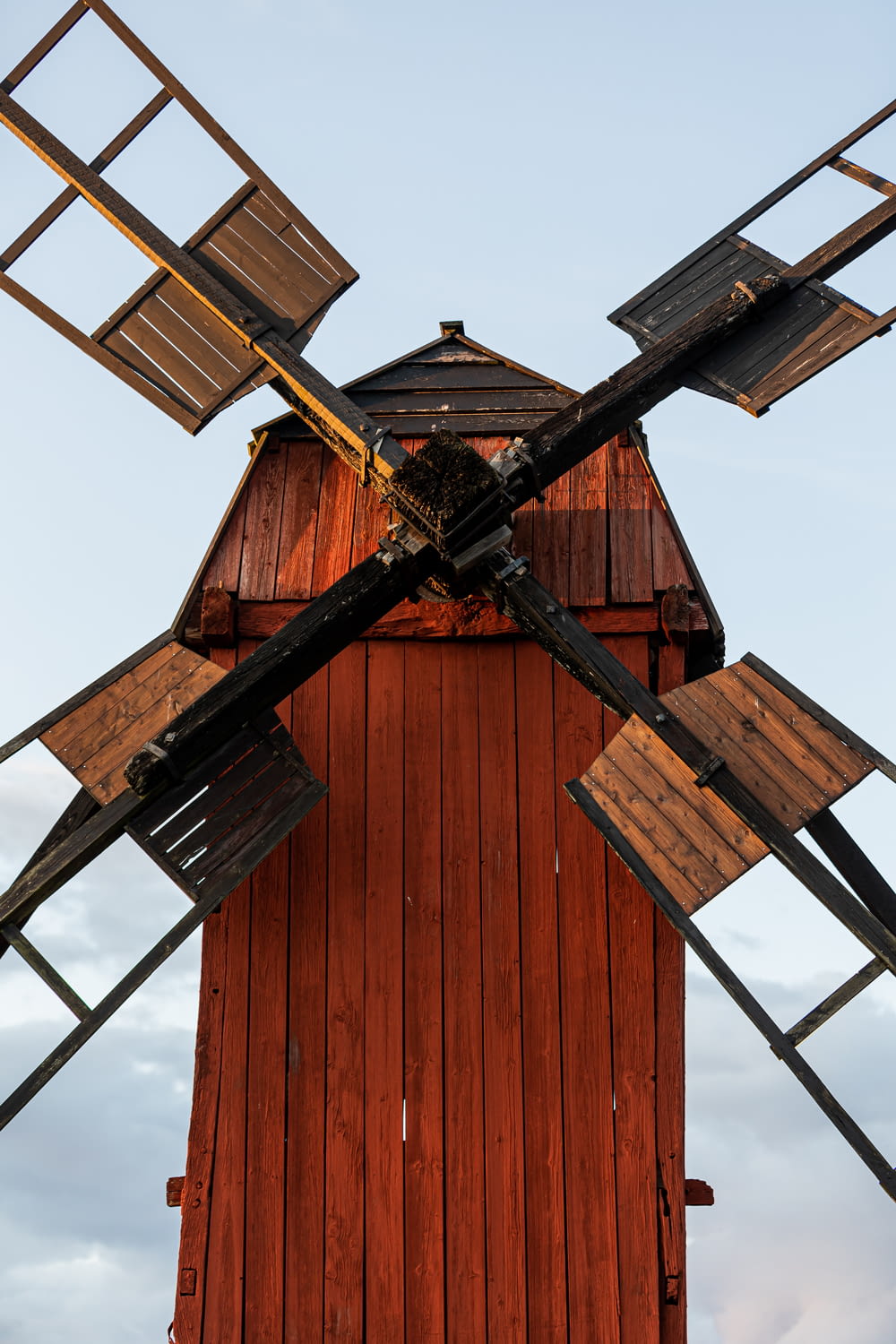 a red wooden building with a windmill on top of it
