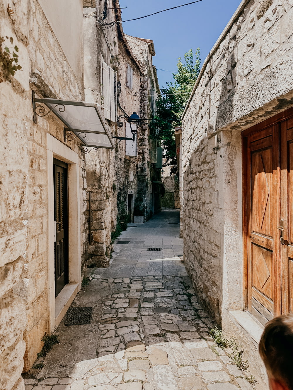a narrow cobblestone street lined with stone buildings